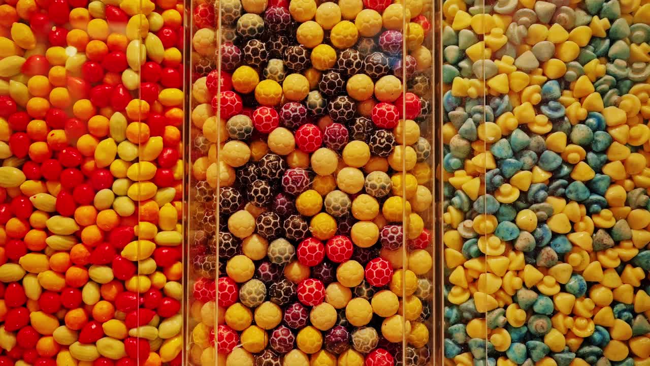 Colorful candies stacked in rows suggest excess and sugar dependence visually