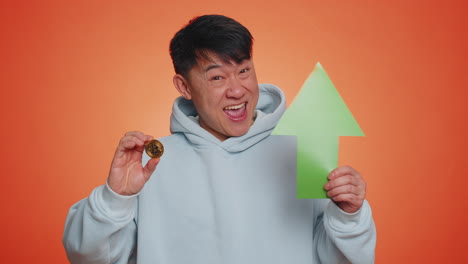 Asian-man-show-golden-bitcoins-BTC-indicating-up-arrow-sign-successful-exchange-rate-increase-mining