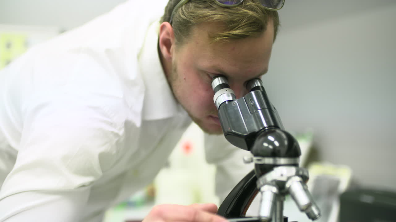 Man Looking Through a Microscope in a Laboratory