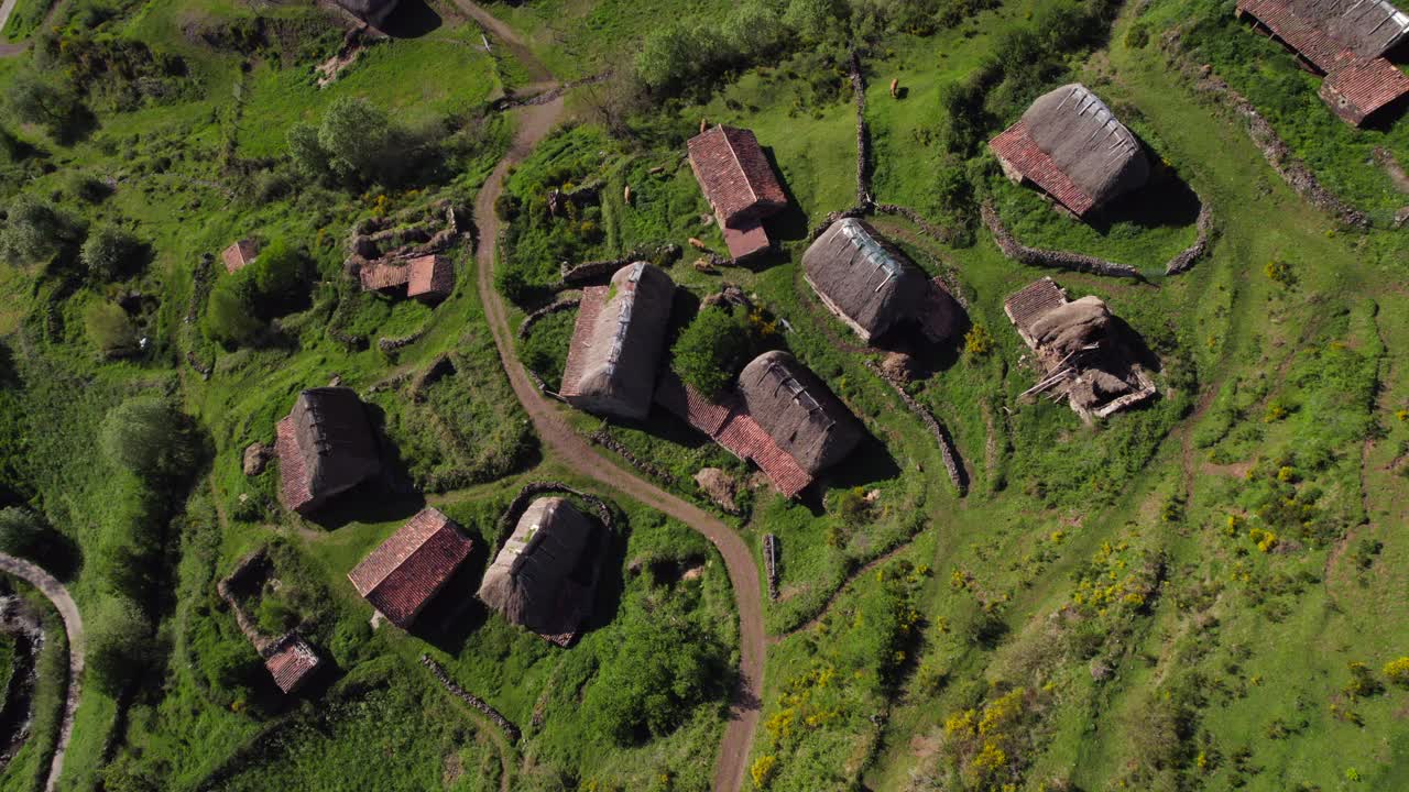 Aerial tilt up view of Pornacal Bra&ntilde;a hut cabin rural village in Somiedo valley, Asturias