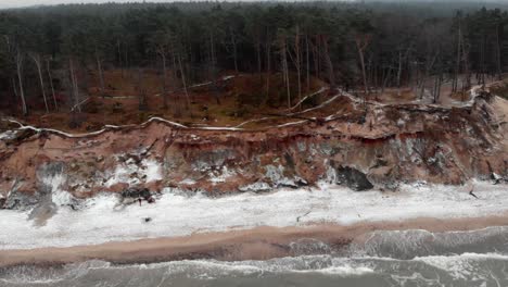 toma aérea de olas rompiendo en la playa de arena de ustka en invierno