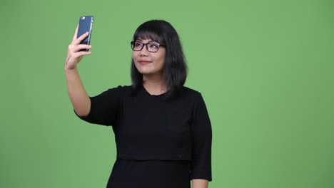 beautiful asian businesswoman taking selfie