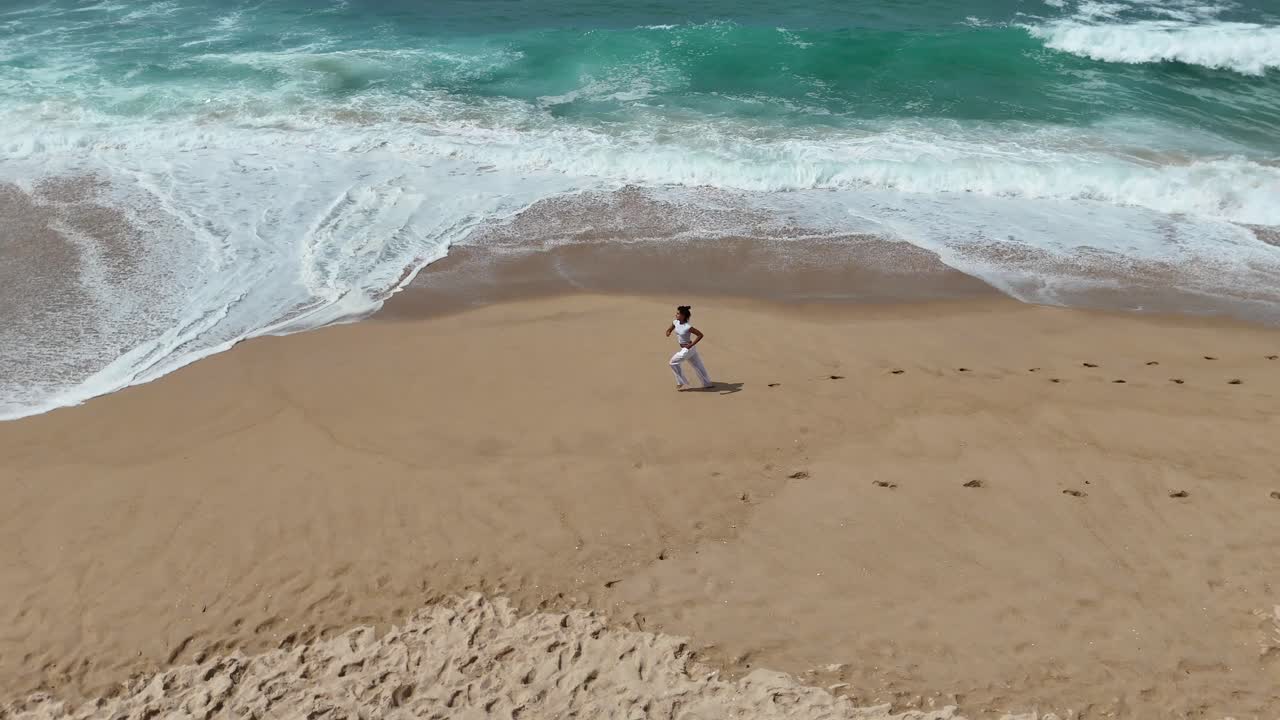 Woman running on a sandy beach next to the ocean
