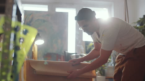 artist wrapping painting in kraft paper