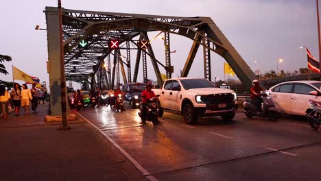 vehículos y personas que cruzan el puente al anochecer