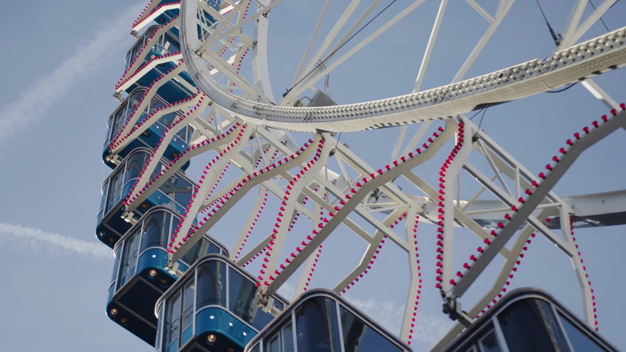 Grande roue en rotation sur fond de ciel bleu clair