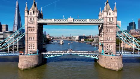 experience a breath-taking aerial view as london's iconic tower bridge is slowly revealed, set against the majestic thames, riverboats, and the stunning city skyline in this captivating video.