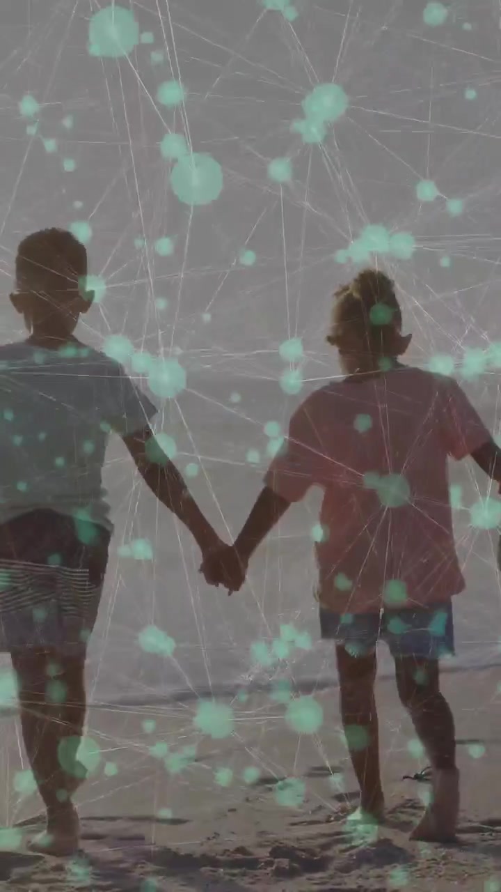 Vertical video: Two kids walking sand, tech nodes overlaying, adult joining hand, trio heading sea