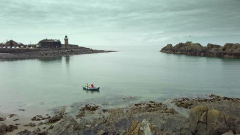 a lone canoe sailing on the sea at portpatrick scotland with moody sky's and calm sea