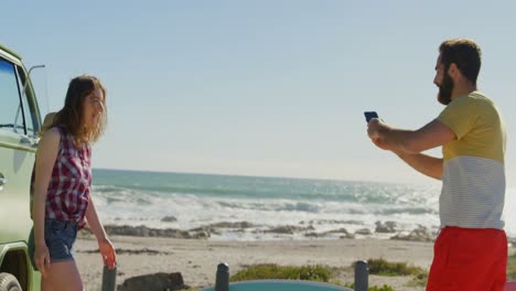 joven feliz haciendo clic y revisando la foto de la mujer en el teléfono móvil 4k