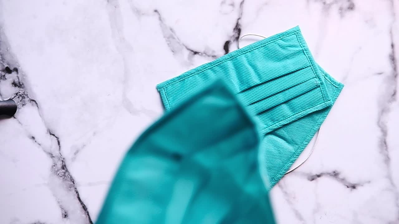 máscaras faciales de azul azulado o turquesa en superficie de mármol blanco