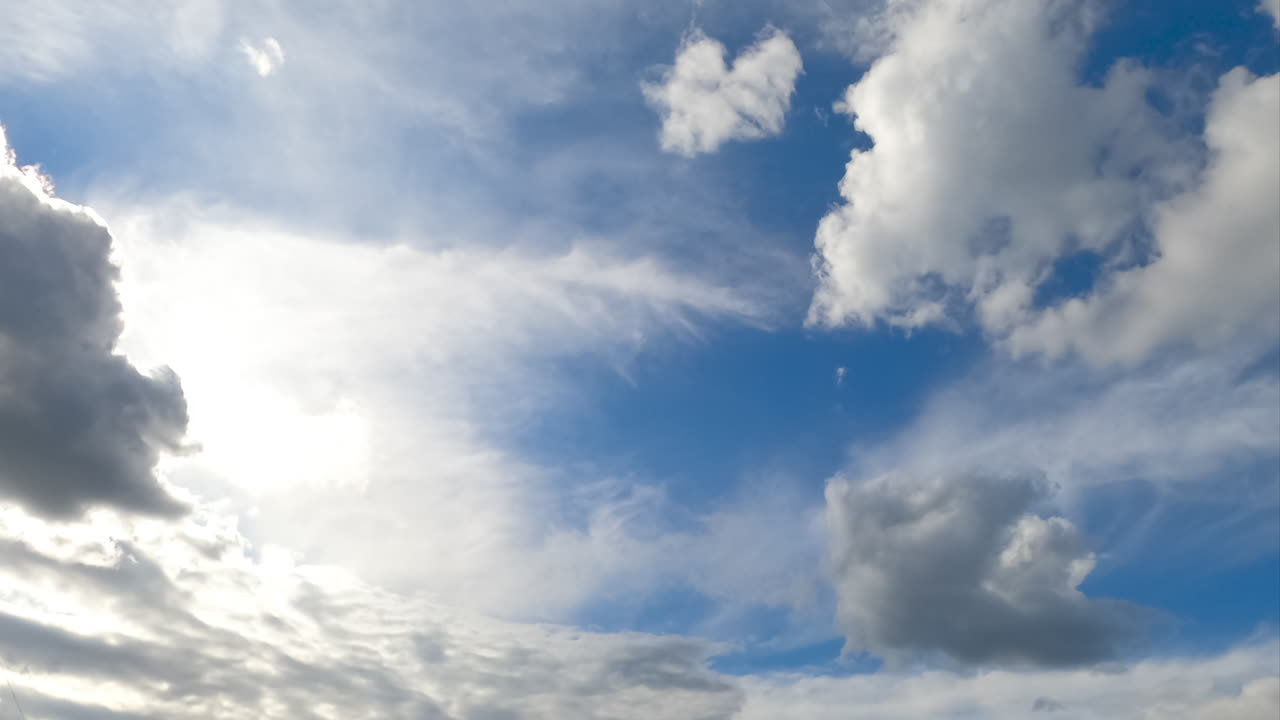 White soft clouds moving quickly by the horizon. Cloudscape formation low angle view. Timelapse.