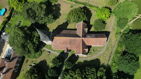 Top-down-push-in-shot-of-St-John-the-Evangelist-church-in-Ickham,-Kent,-with-the-graveyard-in-view