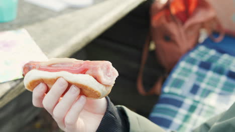 boy holding a hot dog and bun at an outdoor grill party