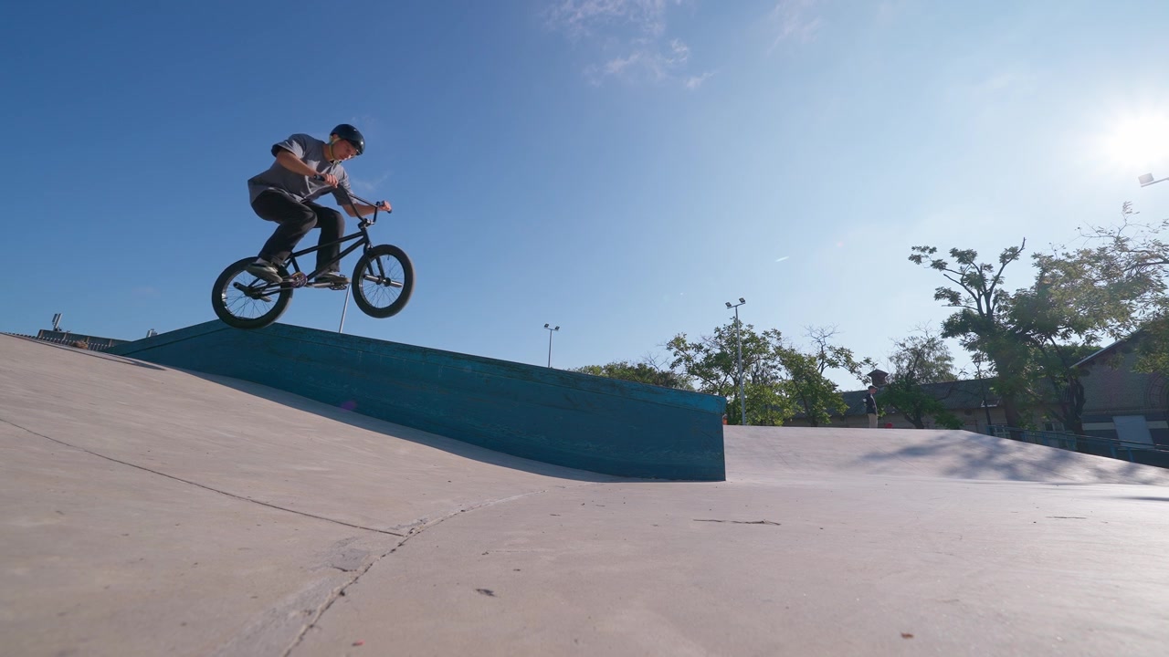 Ung mand udfører et BMX manual-trick i en skatepark