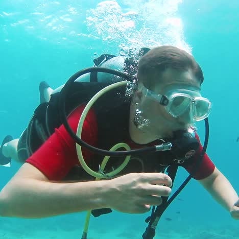 novice diver learns to swim with scuba diving gear