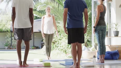 focused diverse seniors having pilates class with female coach, unaltered, in slow motion