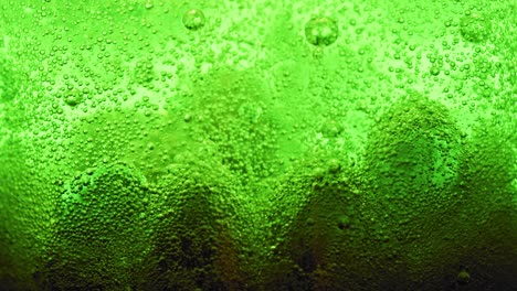 macro shot of big green bubbles on ground of water and many small bubbles sparkling