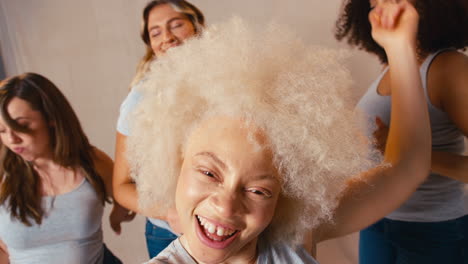 grupo de mujeres vestidas casualmente amigas una con extremidades discapacitadas promoviendo la positividad corporal bailando