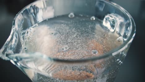 Powder-for-iced-tea-is-placed-in-a-glass-carafe-and-stirred