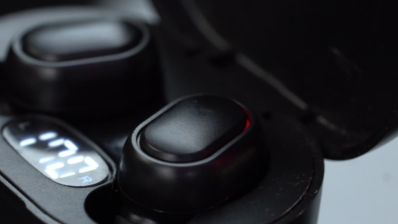 Wireless Earbuds in a Case with a Digital Battery Display Showing 100%