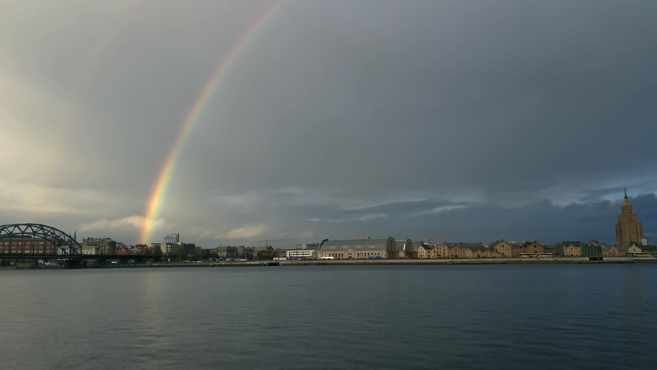 vista de la ciudad desde el otro lado del río y el arco iris en el fondo