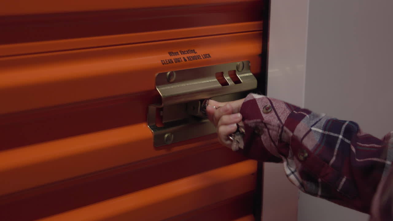 Una donna sblocca la porta di un'unità di deposito.