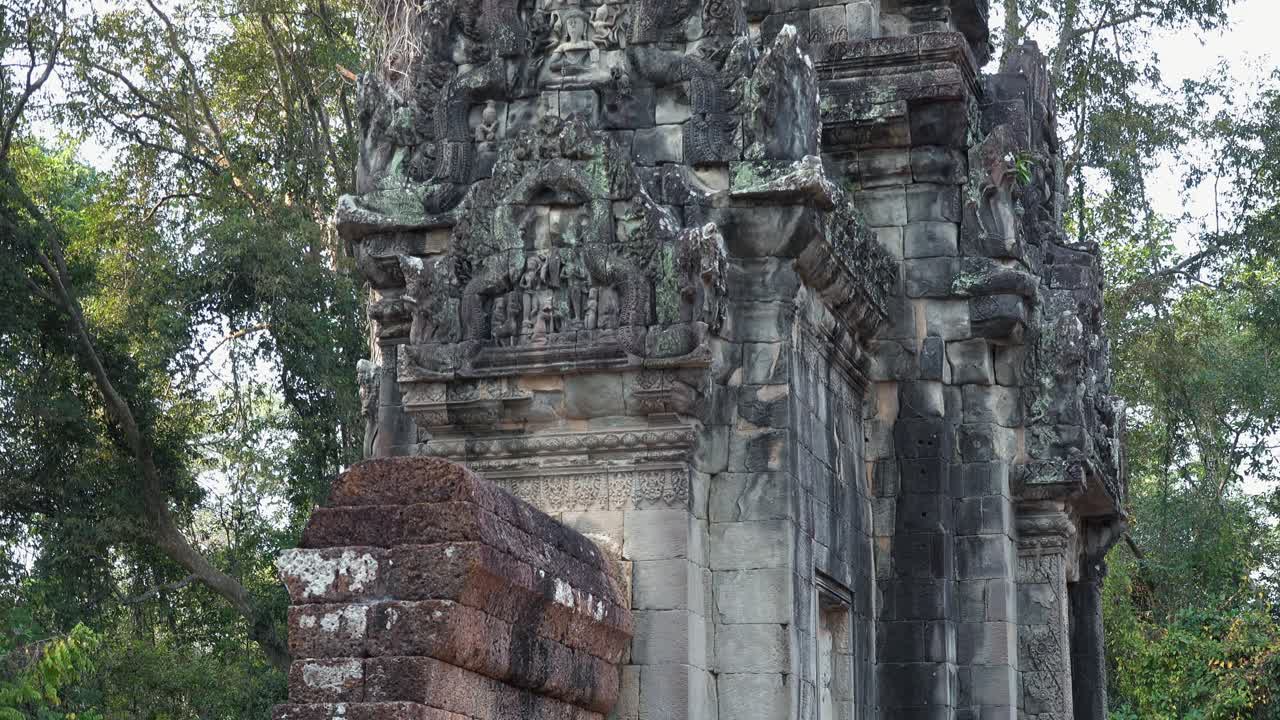 Medium Exterior Tilt up Shot of a Small Temple Ruins Revealing Detailed Carvings in the Jungles of Cambodia Near Angkor Wat