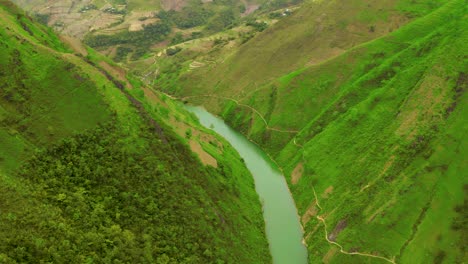 aerial shot over the gorgeous turquoise blue green water of the nho que river in northern vietnam