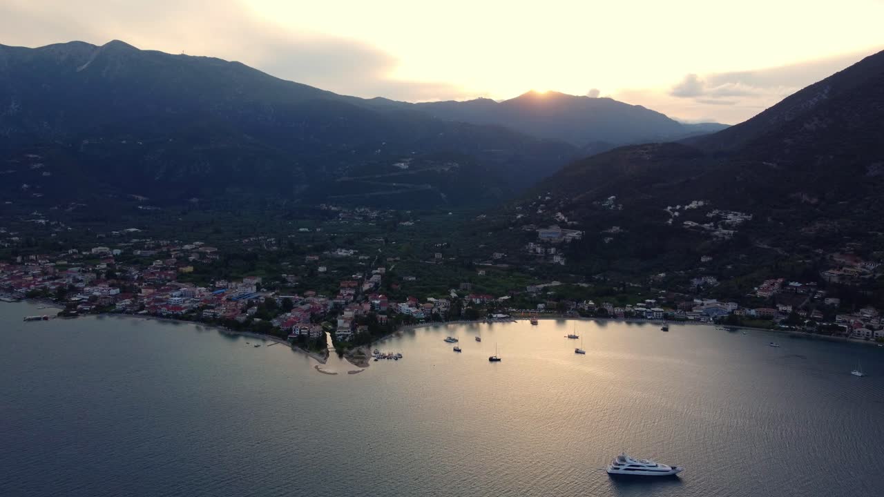 tomada de drone de la hermosa comunidad de la ciudad de nydri en la costa oriental de la isla de lefkada al atardecer rodeada de una vasta área verde con árboles y vegetación exuberante