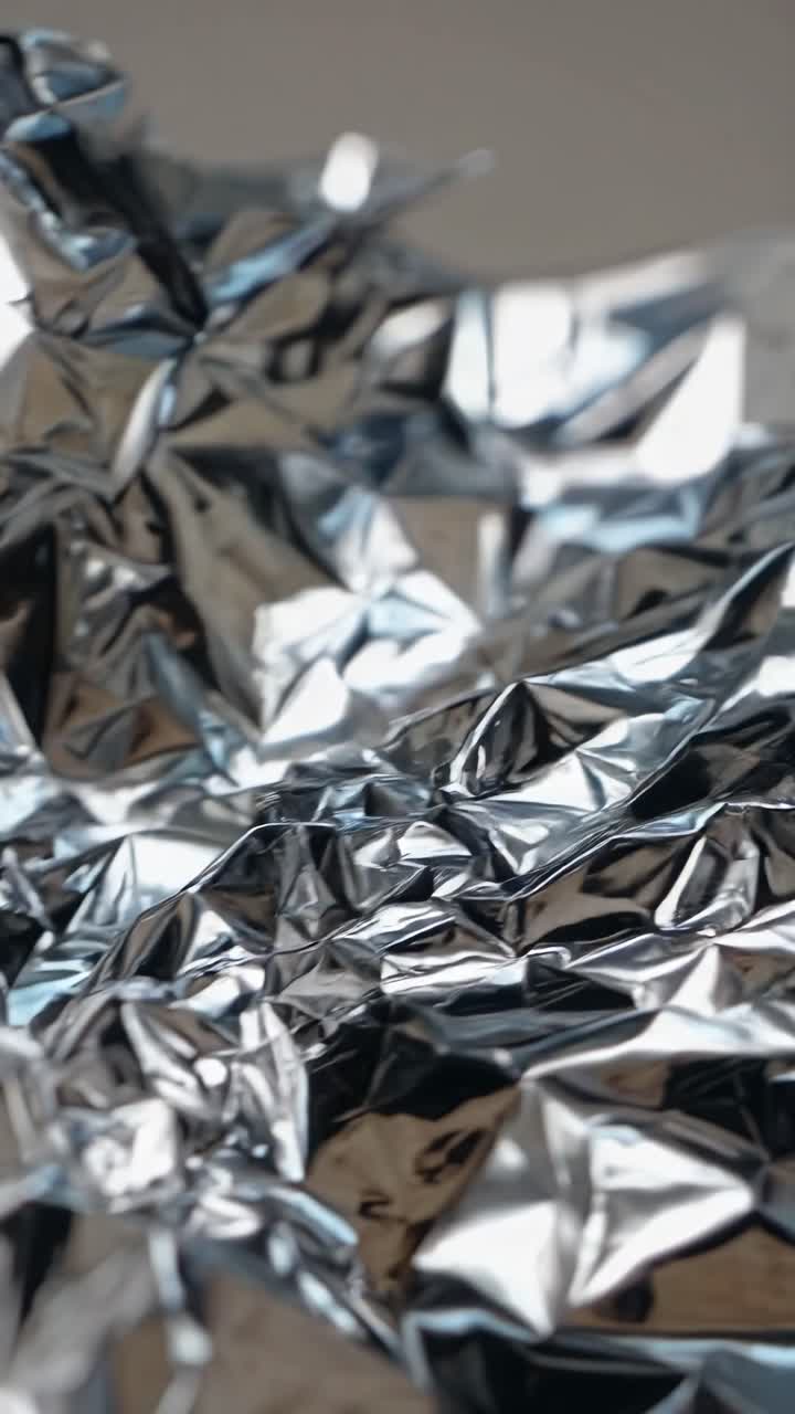 Video ravvicinato di un foglio d'argento accartocciato con una profondità di campo ridotta.