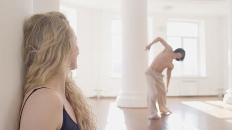 Close-Up-Of-Dancer-Leaning-On-A-Column-While-Her-Male-Co-Worker-Dance-In-The-Studio