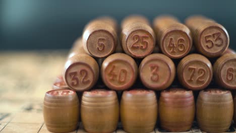 cinematic creative smooth dreamy shot of bingo wooden barrels in a row, woody figures, old numbers background, vintage board game, slow motion 120 fps commercial gimbal video, crane movement