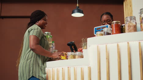 Employee-putting-jars-of-bulk-items-on-scale-at-checkout