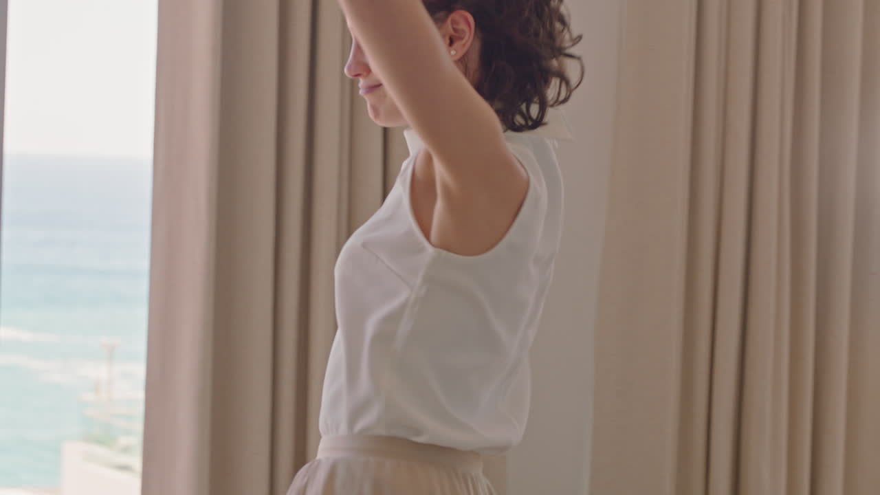 красивая путешественница танцует в гостиничном номере, веселится, празднует летние каникулы, наслаждается беззаботным праздничным образом жизни.