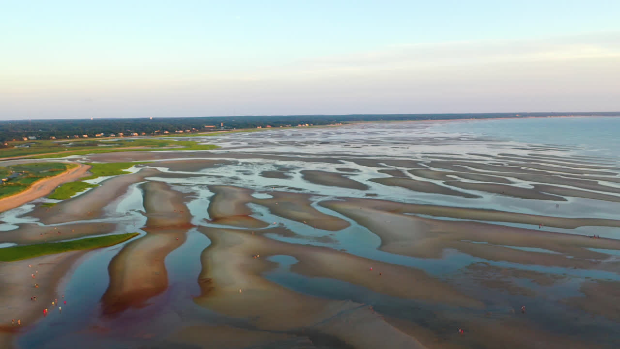 imágenes aéreas de drones de la bahía de cape cod de la playa durante la marea baja con gente caminando, barras de arena y charcos durante la hora dorada