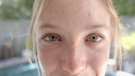 portrait of happy caucasian woman with blond hair in garden, slow motion