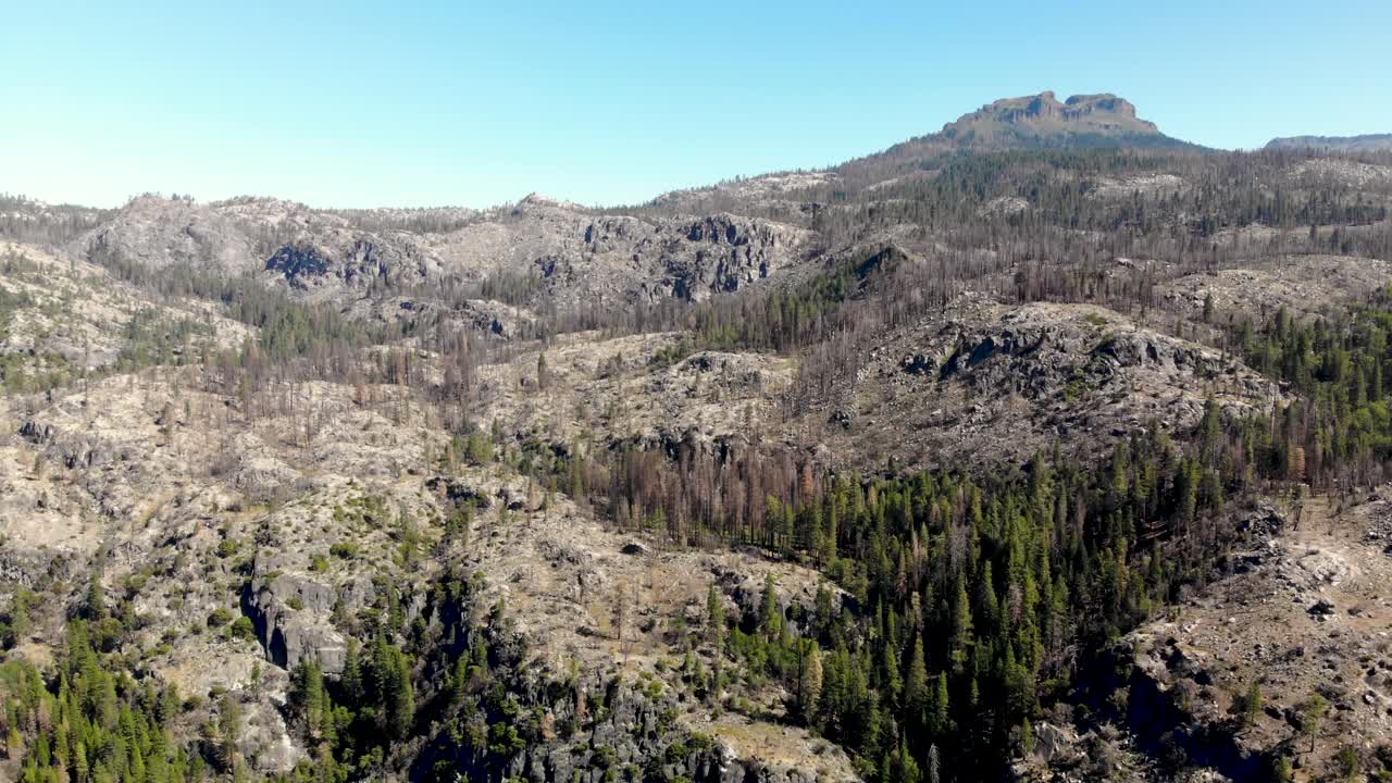 panorámica aérea lenta fuera de la formación rocosa de los dardanelos con una gran zona quemada por el incendio donnell en california.