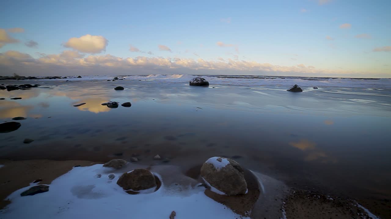эффектный свет заката на зимнем берегу моря со льдом