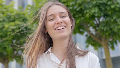 confident corporate woman with wind-blown hair, smiling joyfully