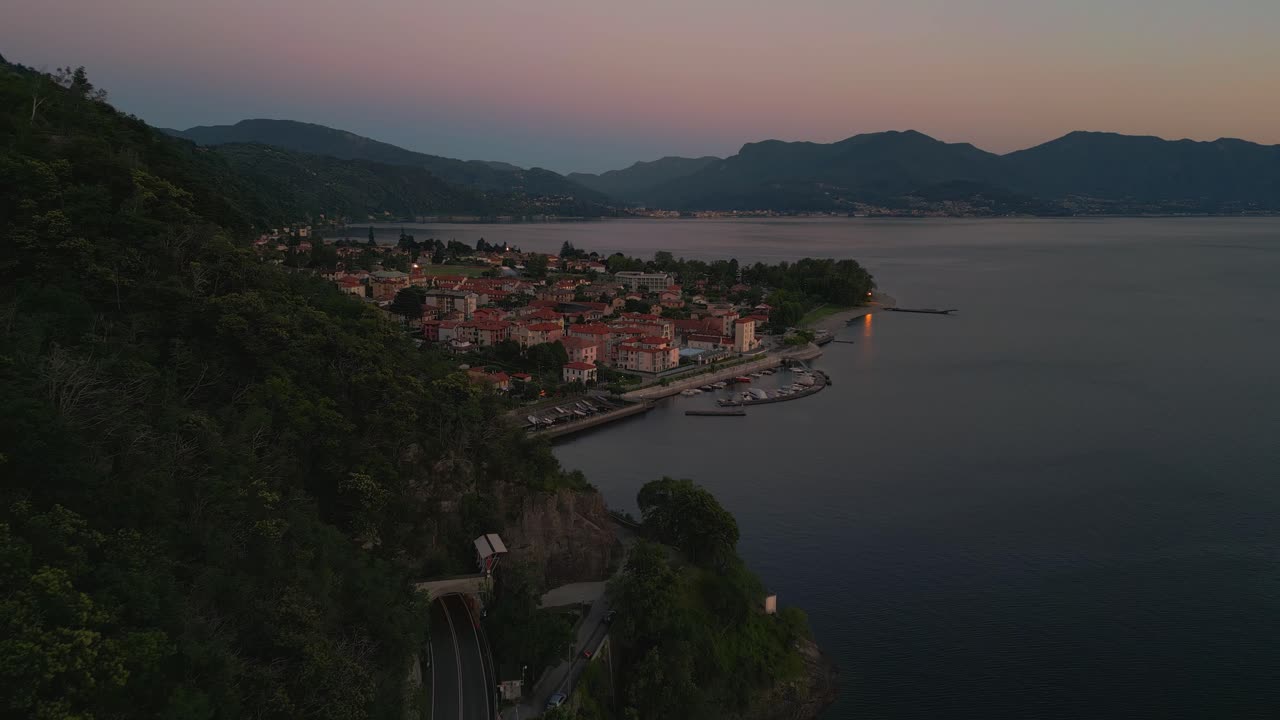 volando a lo largo de una montaña en la orilla del lago lago maggiore en italia y suiza visto desde arriba en vista de pájaro por drones aéreos