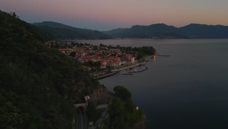 Volando-A-Lo-Largo-De-Una-Montaña-En-La-Orilla-Del-Lago-Lago-Maggiore-En-Italia-Y-Suiza-Visto-Desde-Arriba-En-Vista-De-Pájaro-Por-Drones-Aéreos