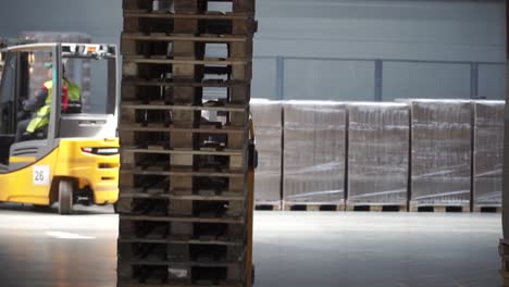 forklift stacking pallets in warehouse