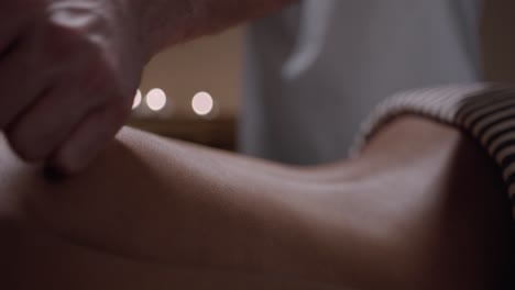 Close-up-of-the-hands-of-a-masseur-giving-a-relaxing-and-relieving-massage-on-a-person's-back