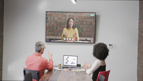 Diverse-business-people-on-video-call-with-caucasian-female-colleague-on-screen