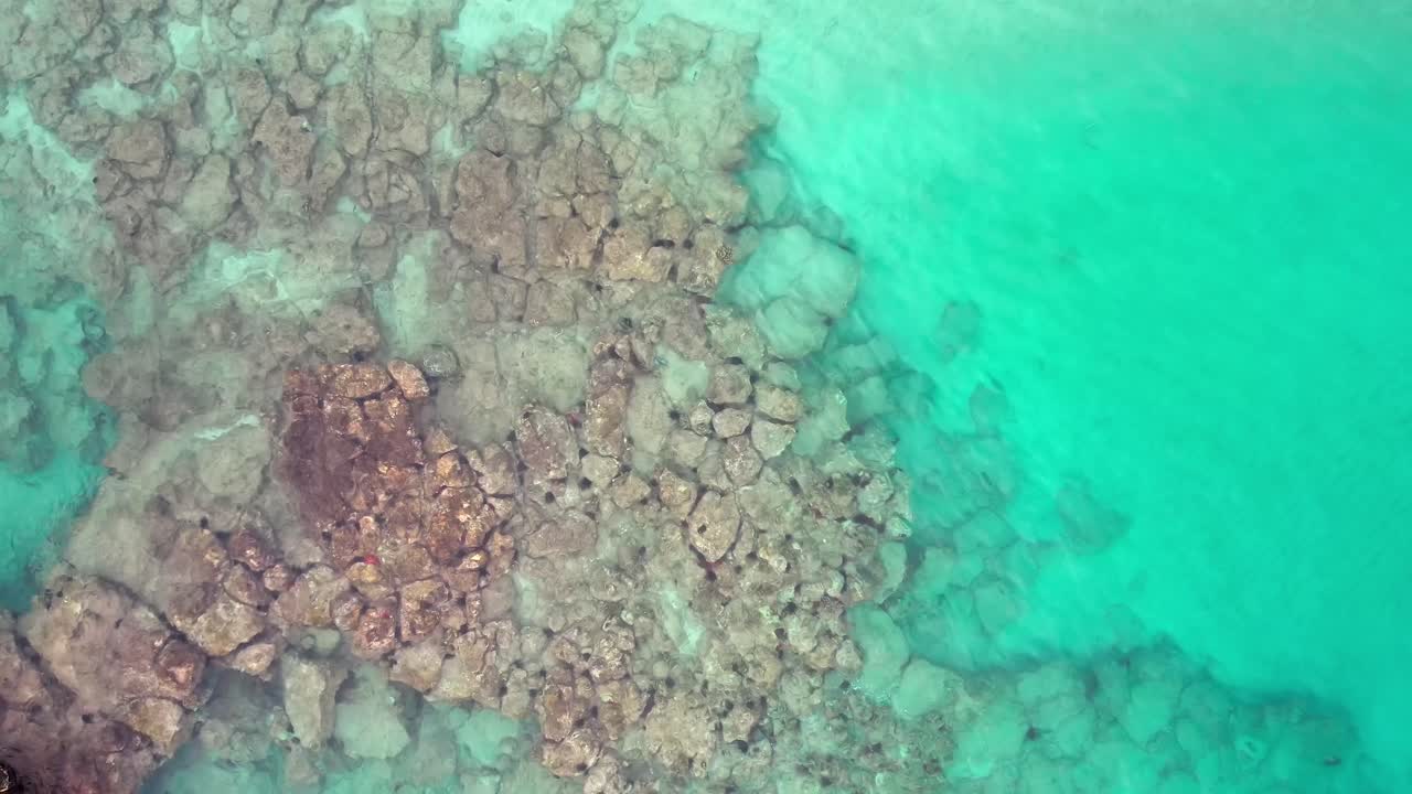 하와이 만에 있는 용암 바위가 가까이 있는 맑은 청록색 바다 위로 공중 조감도