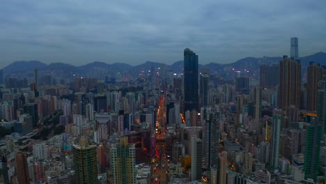 Drone-shot-,traveling-forward,-of-a-big-city-during-a-cloudy-day-with-business-buildings-in-the-distance