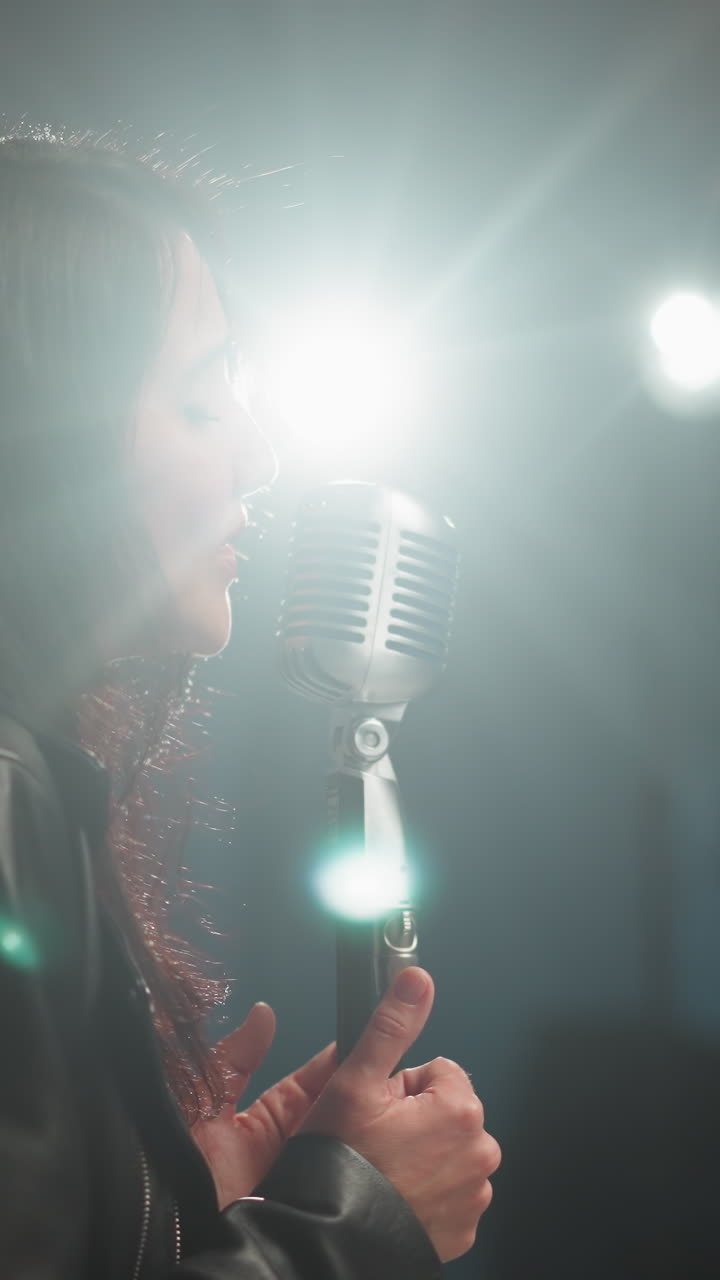 vista borrosa de un cantante y guitarrista actuando en una habitación débilmente iluminada, con luces brillantes brillando en el rostro del cantante, creando una atmósfera dramática y emocional