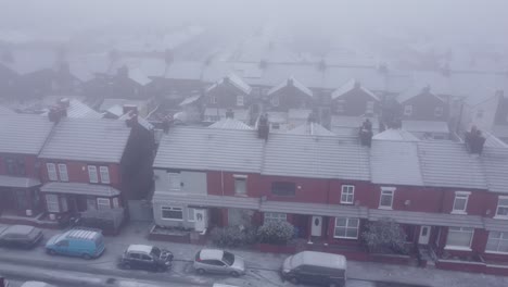 snowy frozen uk neighbourhood homes during cost of living energy crisis aerial panning view