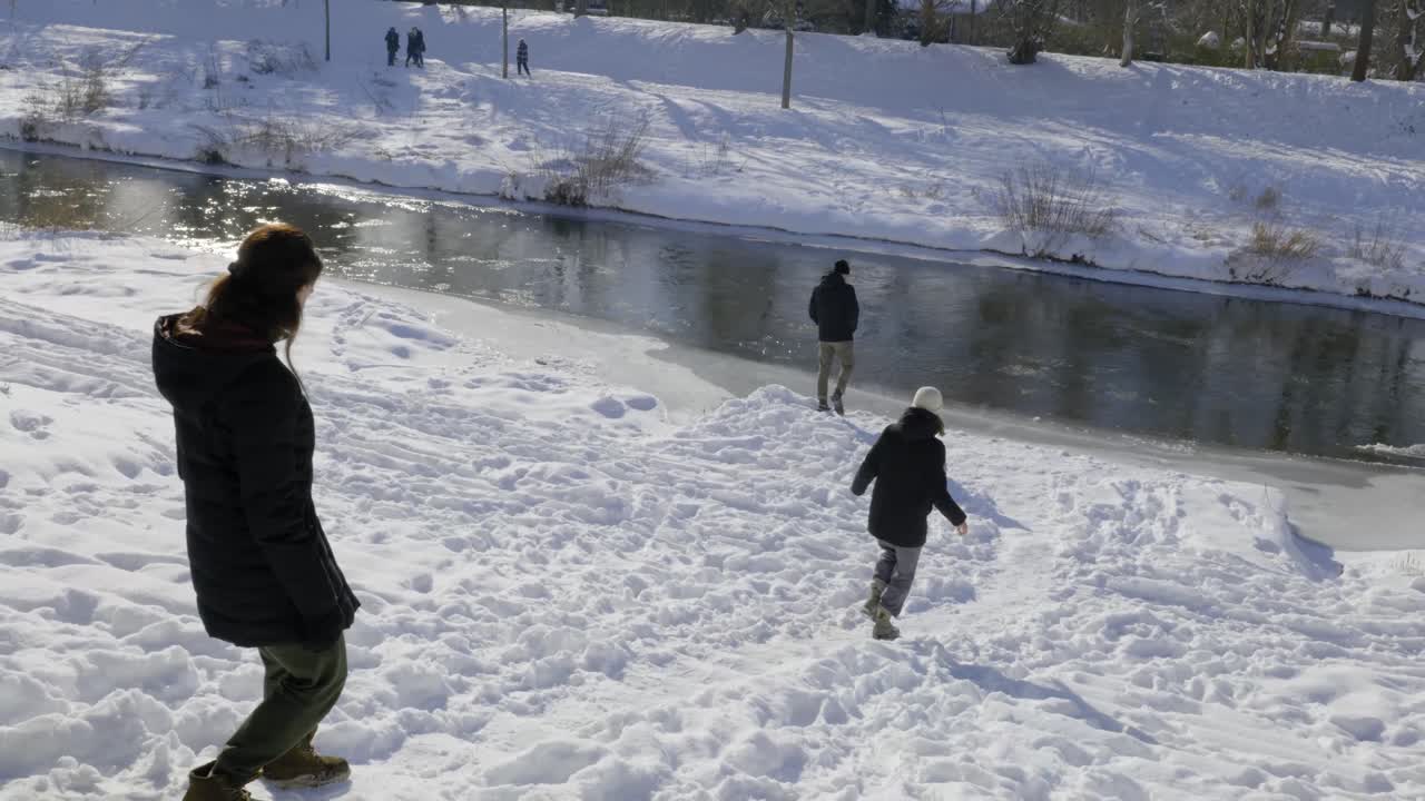 People walking downhill towards a River
